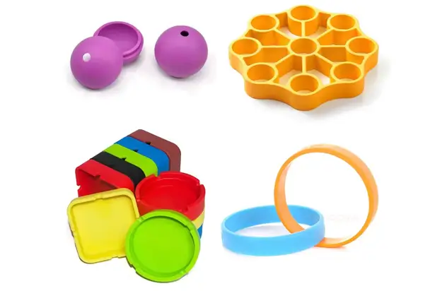 A collection of colorful silicone objects including a pair of purple capsules, an orange honeycomb-shaped trivet, a stack of multicolored, nested measuring cups, and two wristbands in orange and blue.