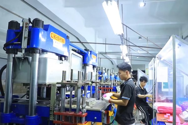 Workers operating advanced silicone molding machines in a factory production workshop, ensuring precision manufacturing and quality assurance.