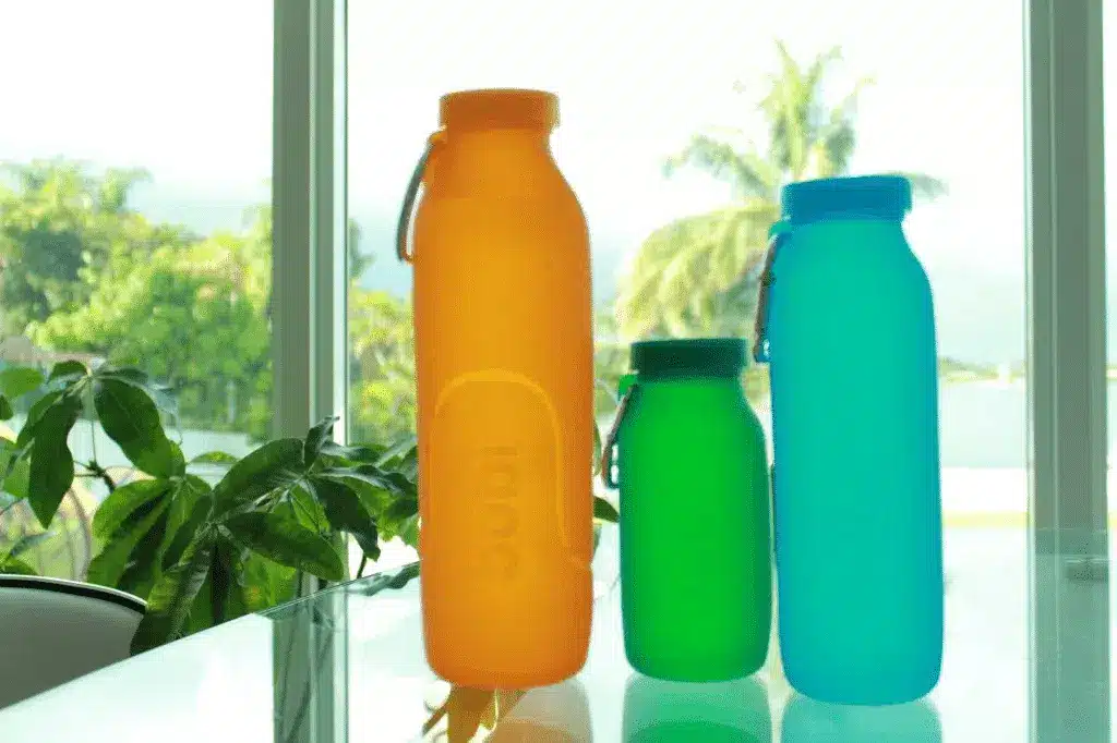 Three colorful silicone bottles made in China, demonstrating material quality from a professional manufacturer.