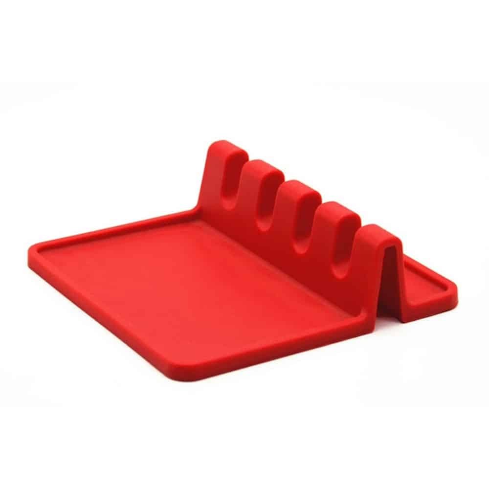 Green silicone table mat designed in the shape of a leaf, placed on a wooden dining table with a plate, fork, and glass, showcasing its food-grade, non-slip, and decorative qualities.